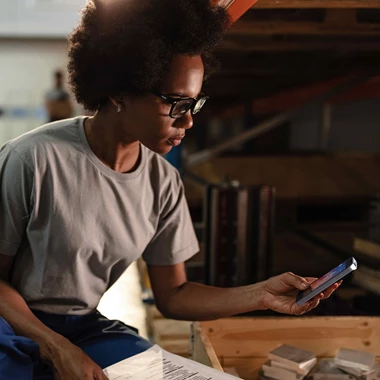 Woman in production facility checking her mobile phone